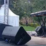 Garden event stage with a speaker, stage monitor and keyboard beside a white marquee in Kenya