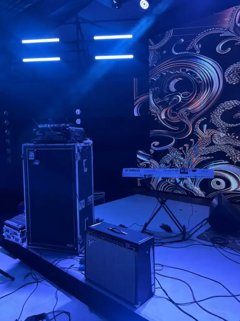 Ampeg bass cabinet, Fender guitar combo and a Yamaha Motif keyboard set on a blue-lit stage in Kenya