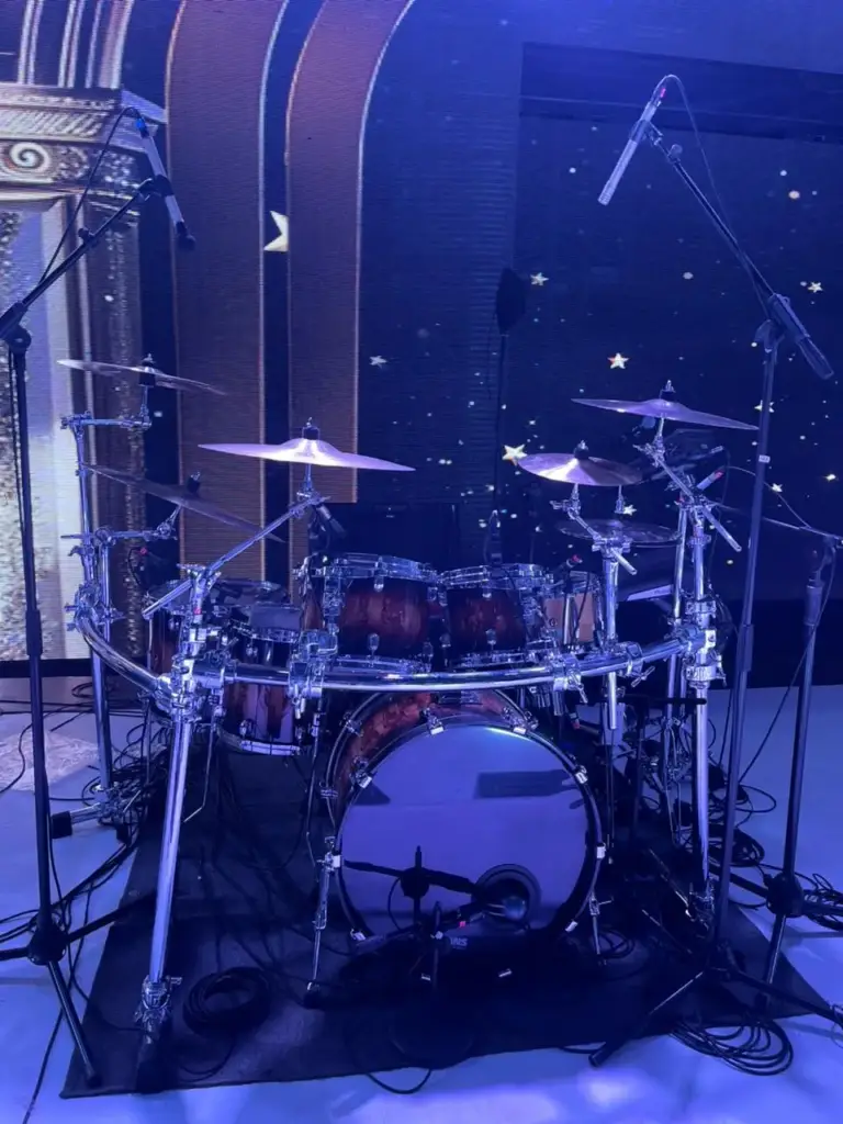 Rack-mounted drum kit with overhead microphones under a starry blue LED backdrop in Kenya