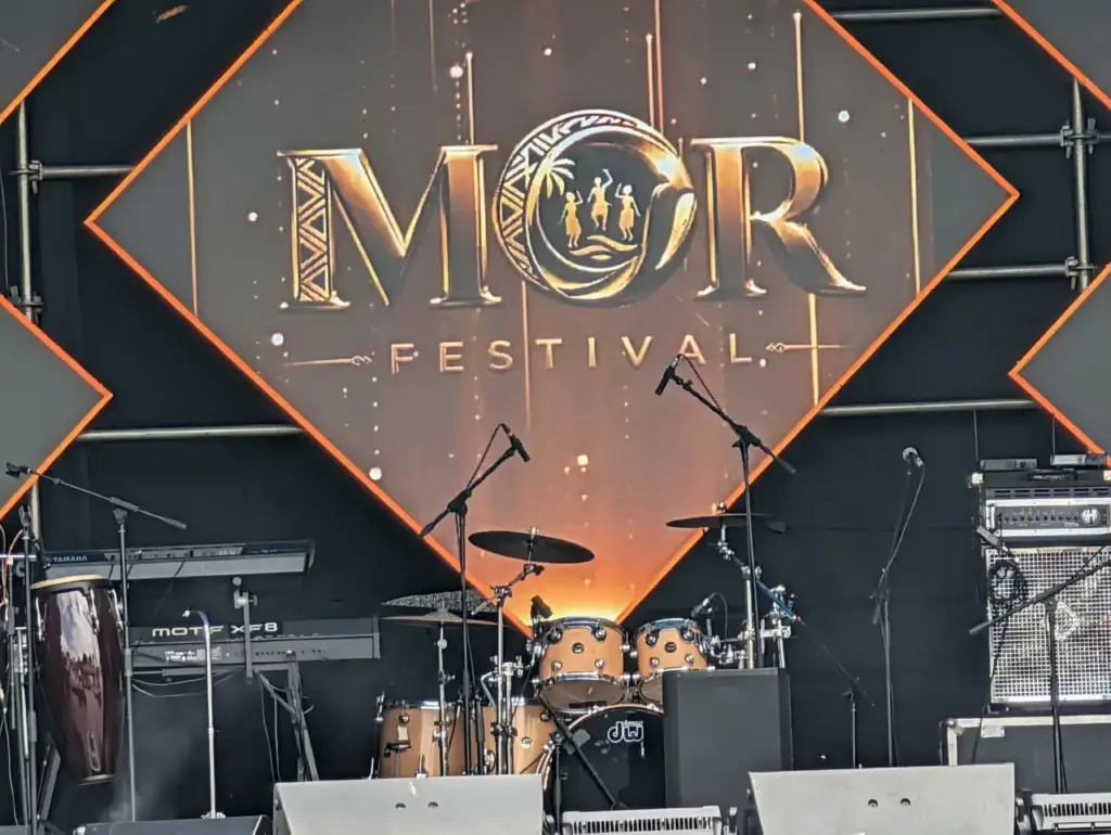 MOR Festival stage set with a DW drum kit, congas, a Yamaha Motif XF8 keyboard and a bass rig in front of the festival backdrop in Kenya