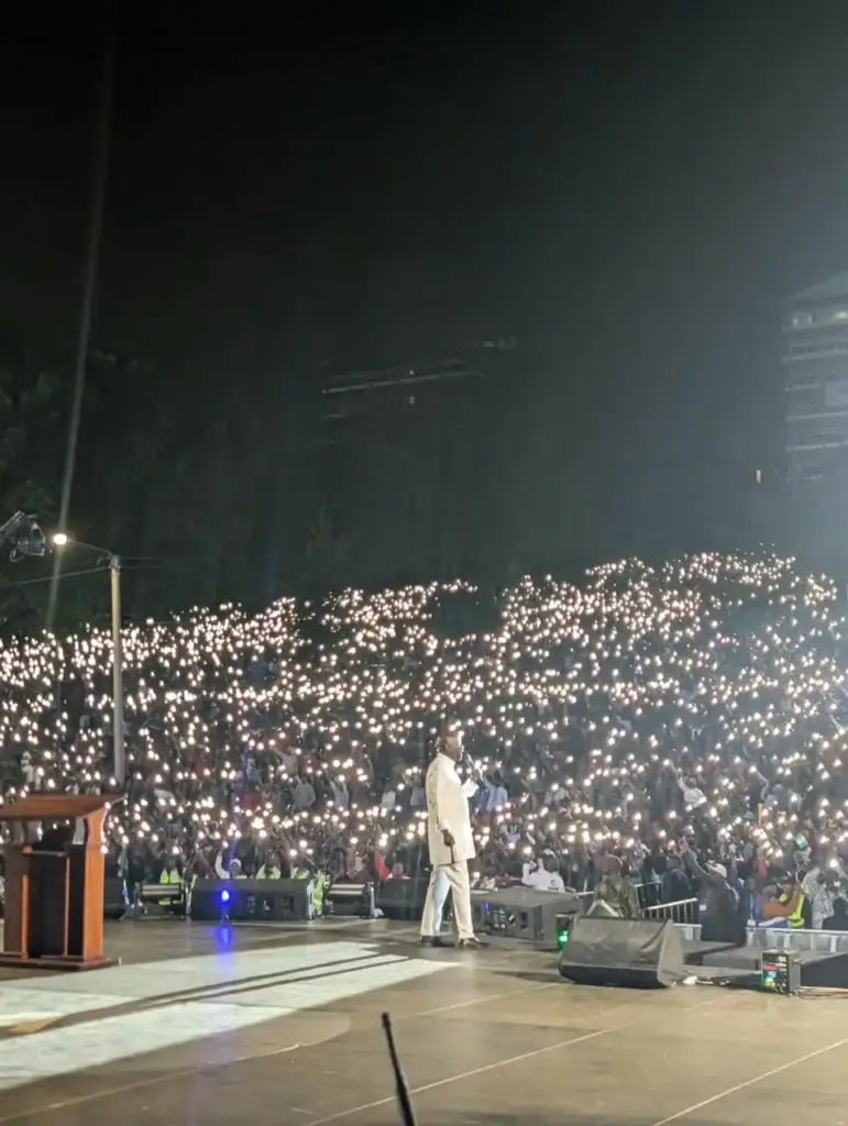 Speaker on stage as thousands of phone lights fill Uhuru Park during an evening session of Rhema Feast 2026 in Nairobi