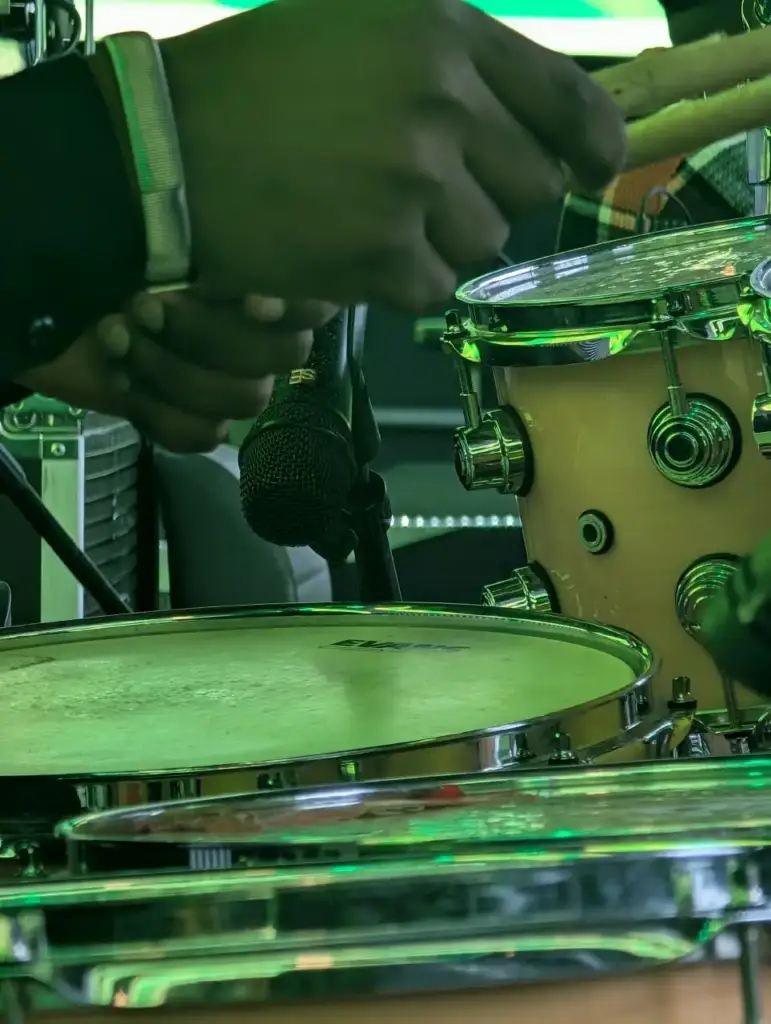 Drummer's hands over the snare with a microphone in position on the house backline kit at Rhema Feast 2026