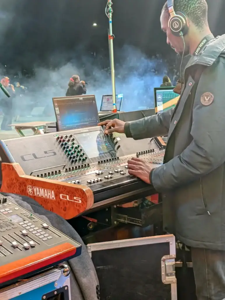 Engineer riding faders on a Yamaha CL5 while mixing stage monitors during a worship set at Rhema Feast 2026, Uhuru Park Nairobi