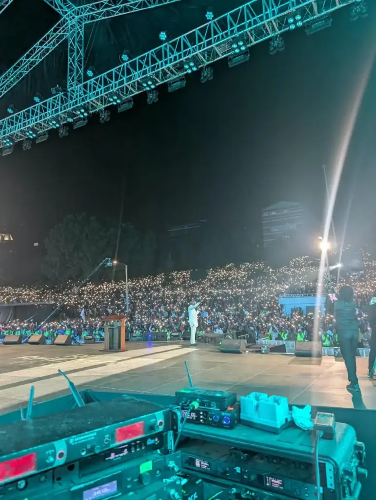Radio microphone receiver racks at the stage edge under teal stage lighting at Rhema Feast 2026 in Nairobi